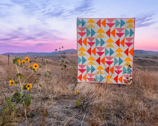 Together quilt out in the hills with sunflowers and the sunset.